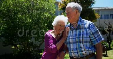 积极行动的高加索老年夫妇在<strong>养老院</strong>花园散步的正面景色